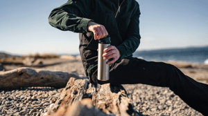 Man with coffee thermos while hiking